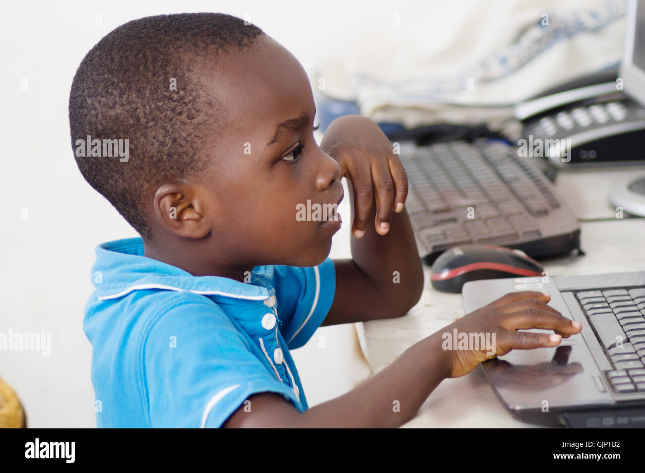 La curiosité donne à l'enfant une maîtrise de l'ordinateur Banque D'Images