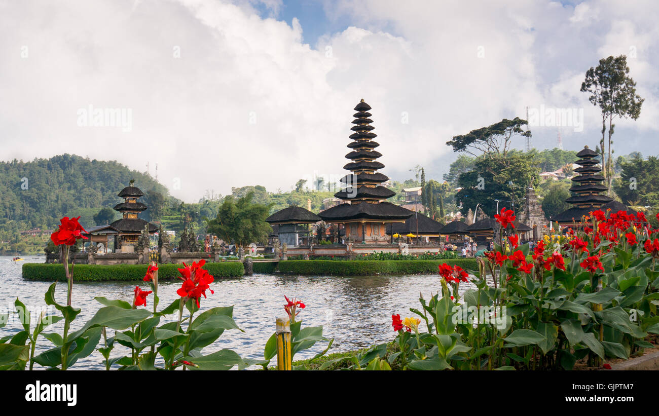 Fleurs rouge en face de la Pura Ulun Danu Bratan - un saint temple de l'eau - sur Bali Banque D'Images