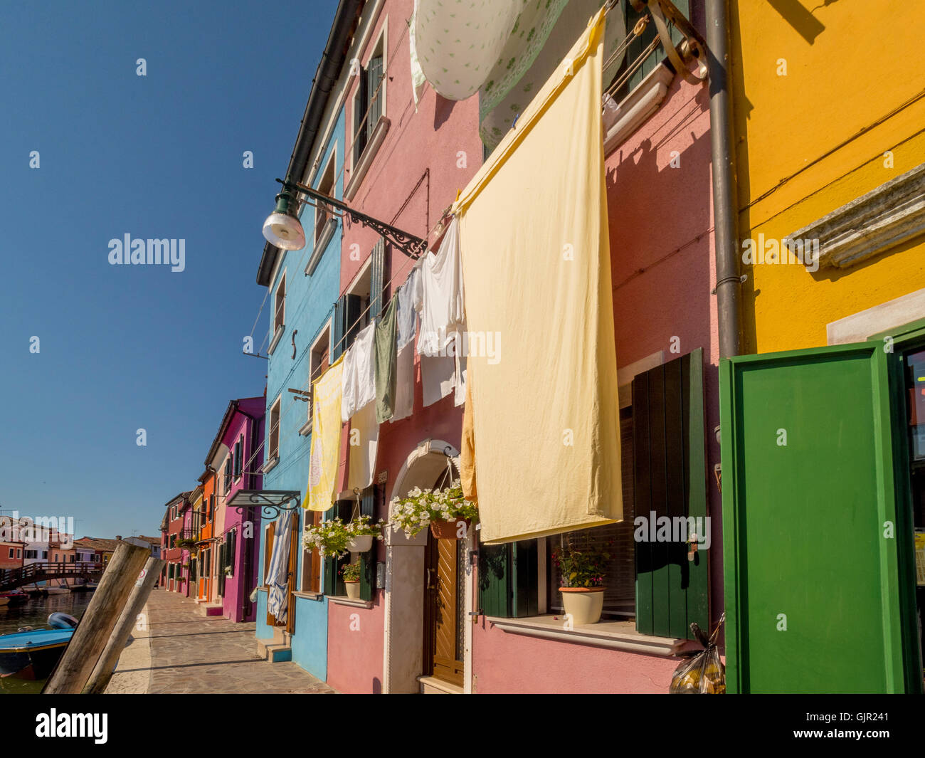Maisons en terrasse aux couleurs vives avec buanderie suspendue à l'extérieur sur les lignes de lavage sur l'île de Burano. Venise, Italie. Banque D'Images