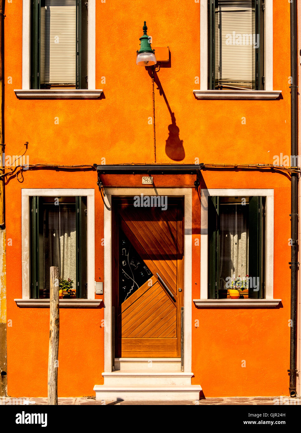 Orange rendu extérieur d'une maison traditionnelle sur l'île de Burano. Venise, Italie. Banque D'Images
