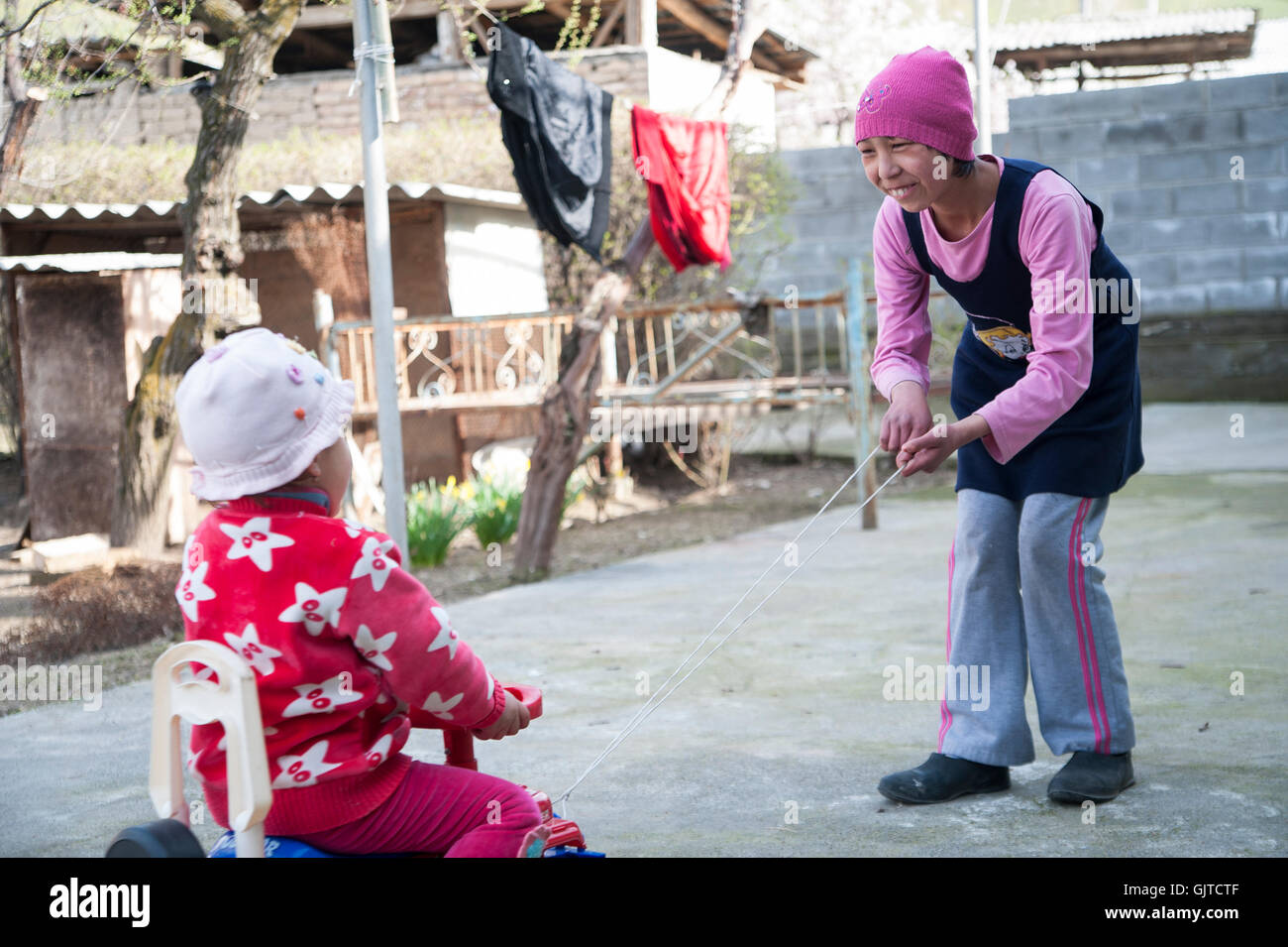 Jalabat, Kirghizistan : Enfants jouant dans un jardin dans un village. Banque D'Images