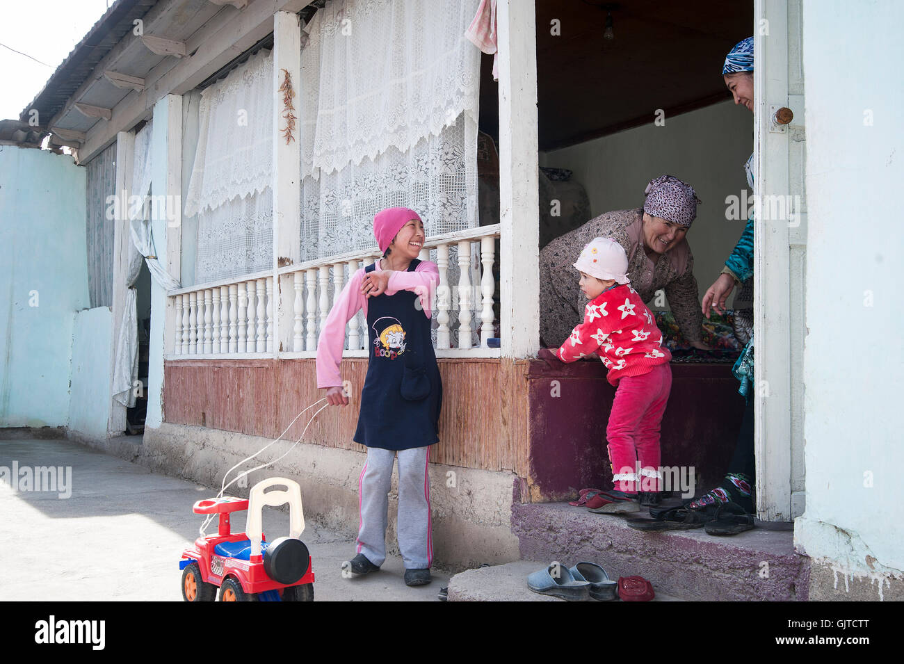 Jalabat, Kirghizistan : Enfants jouant dans un jardin dans un village. Banque D'Images