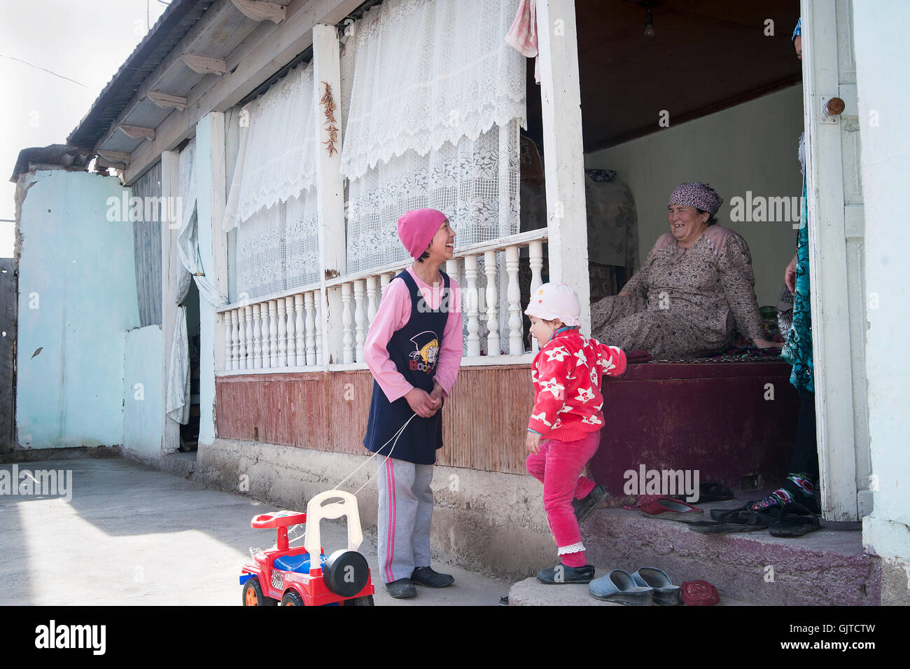 Jalabat, Kirghizistan : Enfants jouant dans un jardin dans un village. Banque D'Images