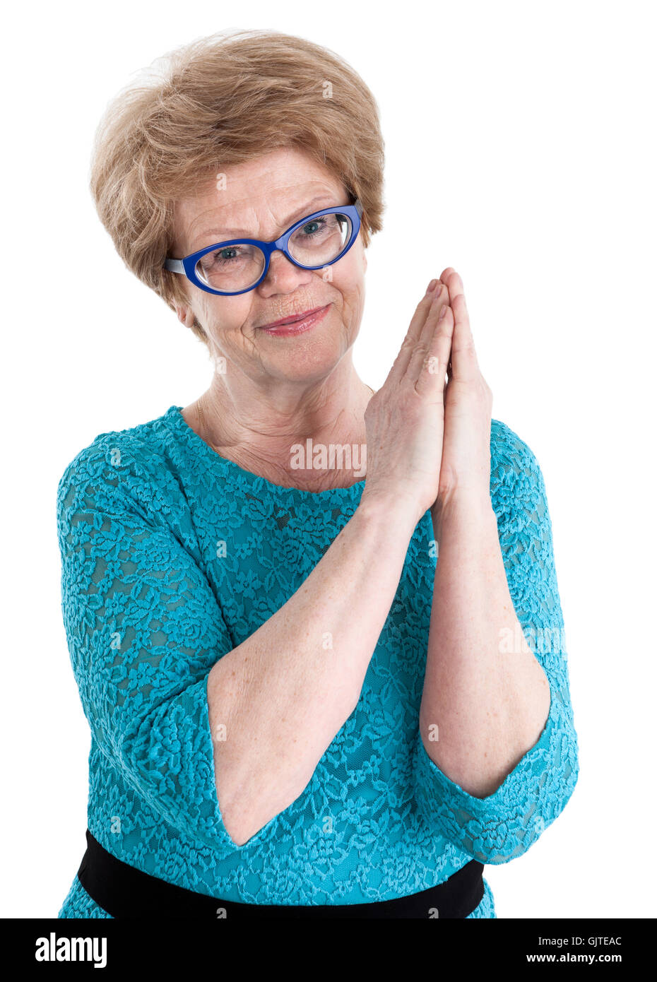 Portrait de femme joyeuse de l'âge de la retraite avec les mains pliées, isolé sur fond blanc Banque D'Images