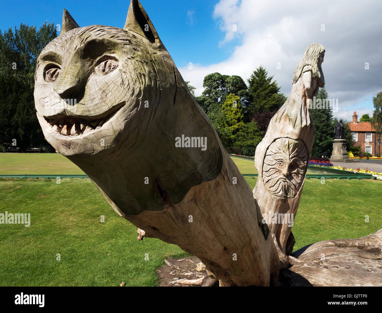 Chat de Cheshire et Alice dans Alice au Pays des merveilles en bois la sculpture dans les jardins Spa Nord Ripon Yorkshire Angleterre Banque D'Images