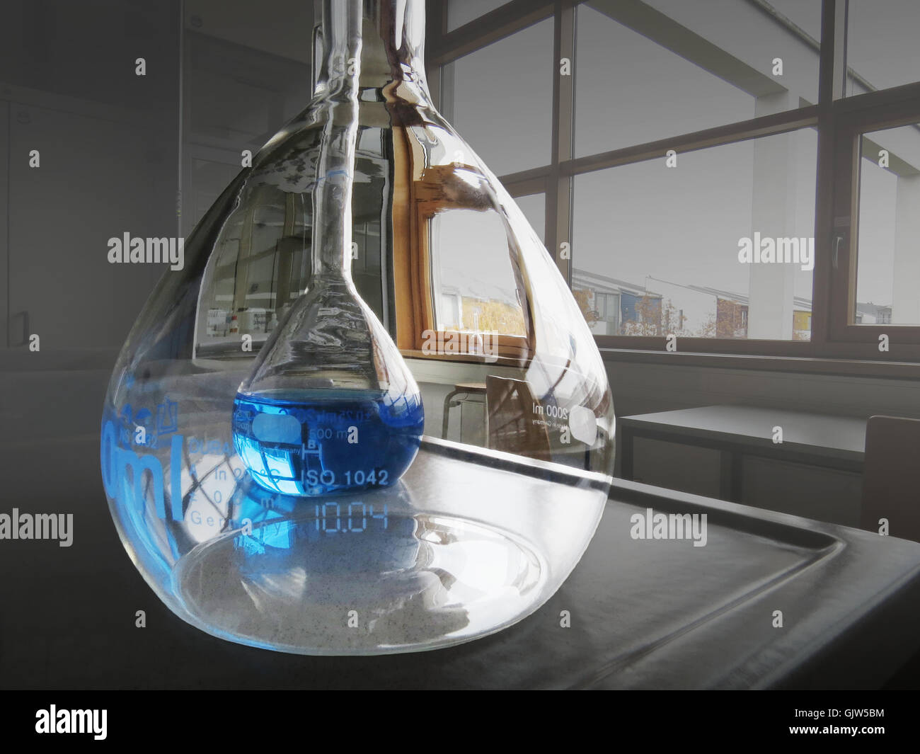 Grand Ballon brillant reflétant chimiques et de plus petits ballon avec une solution bleue derrière Banque D'Images