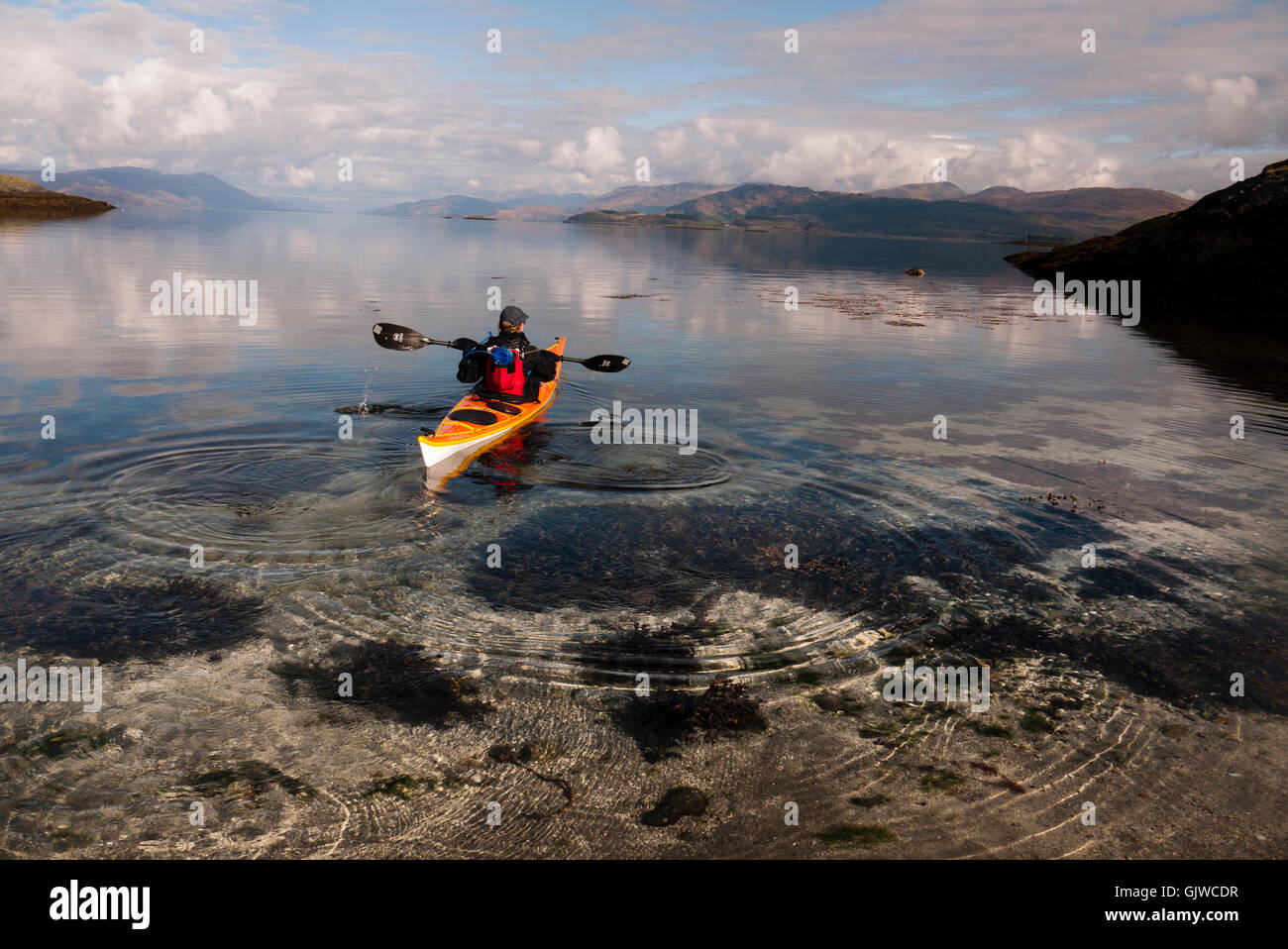Un kayakiste de mer dans une baie isolée sur l'île de Lismore dans les Hébrides intérieures de l'ouest de l'Écosse. Banque D'Images