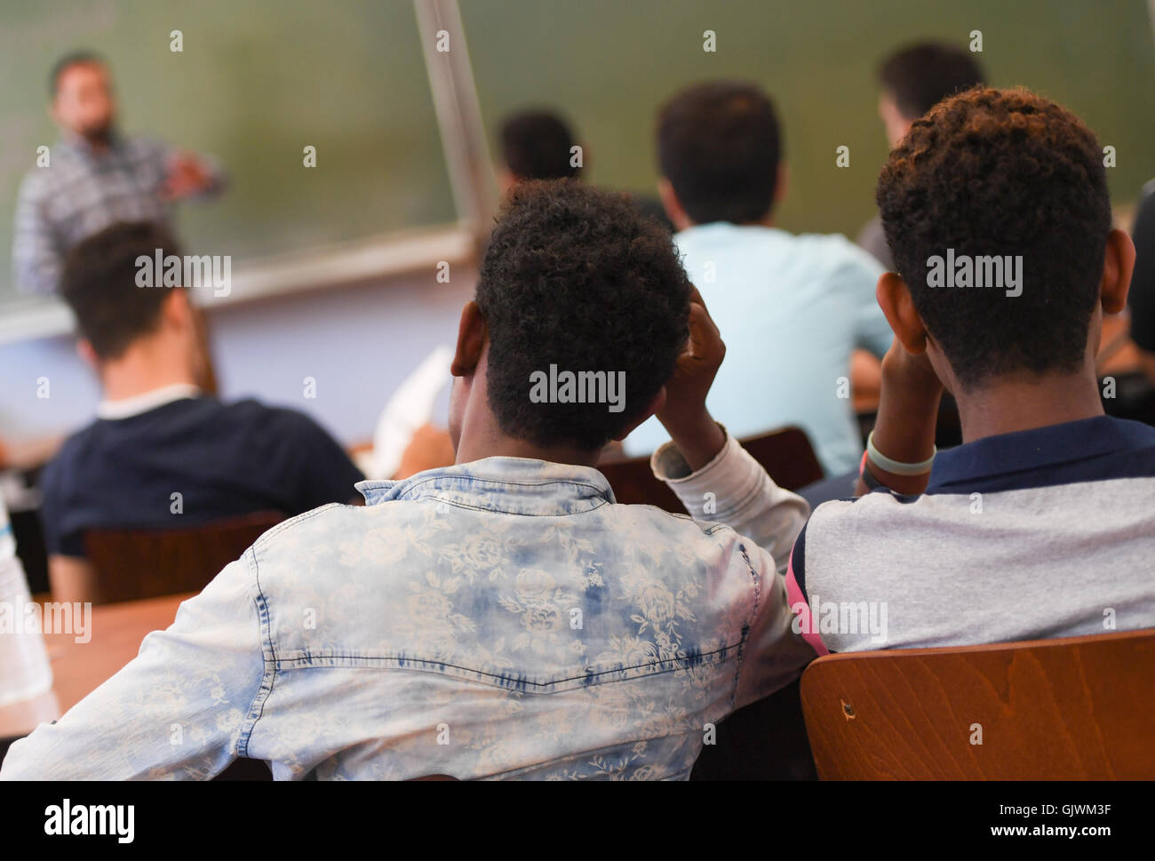 Francfort, Allemagne. Août 17, 2016. Les réfugiés et les migrants assis dans une salle de classe au centre de formation professionnelle de la Chambre des Métiers à Francfort, Allemagne, 17 août 2016. Le ministère de l'économie de Hesse a commencé le projet pilote de l'économie 'intègre', au cours de laquelle les jeunes réfugiés et migrants sont pris en charge de leur orientation d'emploi jusqu'à leur formation. PHOTO : ARNE DEDERT/dpa/Alamy Live News Banque D'Images