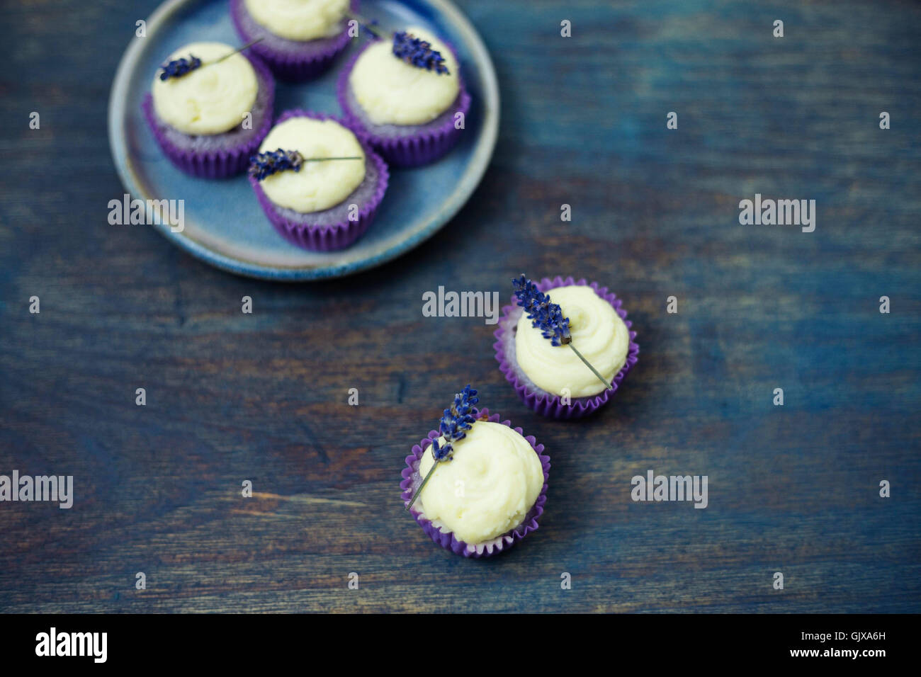Mini lavande cupcakes avec glaçage au mascarpone sur table en bois. Gros plan avec une faible profondeur de champ et d'un grand espace de copie. Banque D'Images