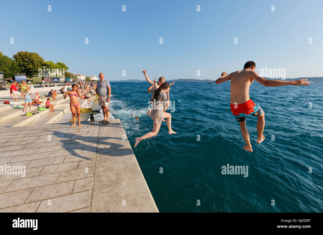 Les touristes de sauter dans l'eau, près de l'orgue de la mer à Zadar Banque D'Images