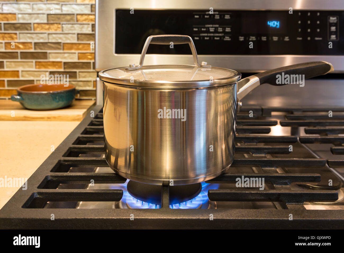 Close-up de pot en acier inoxydable cuisinière à gaz sur l'élément de cuisson en cuisine intérieur accueil gamme contemporaine Banque D'Images