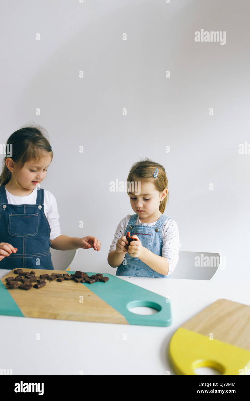 Deux petites filles jouant avec du chocolat Banque D'Images
