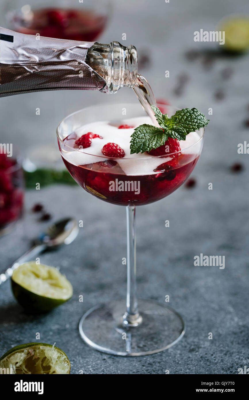 Un verre de champagne à la framboise et Grenade Cocktail est surmontée de champagne Photo Stock