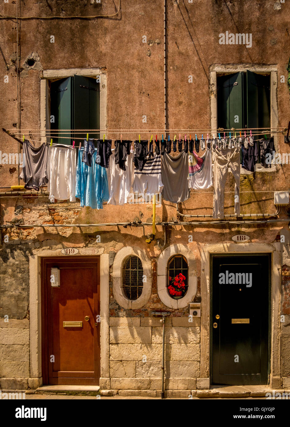 Les bâtiments traditionnels avec les vénitiens stores et volets aux fenêtres, pendu à une blanchisserie avec lave-ligne. Venise, Italie. Banque D'Images