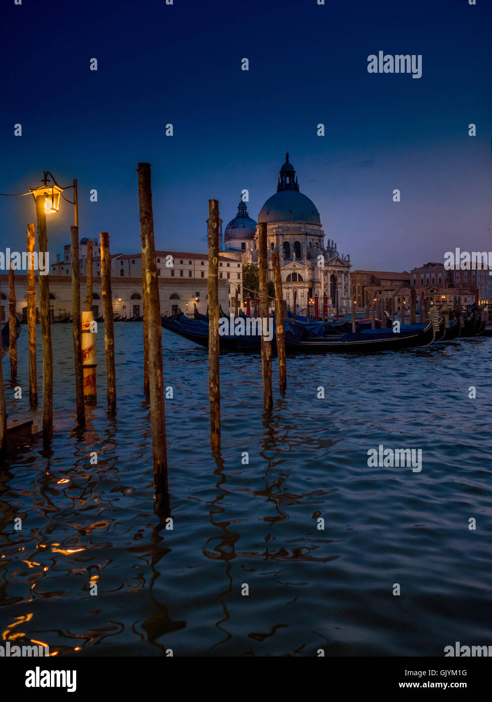 Pour la nuit amarrés Gondoles sur le Grand Canal, avec l'église de Santa Maria della Salute en arrière-plan. Venise, Italie,. Banque D'Images