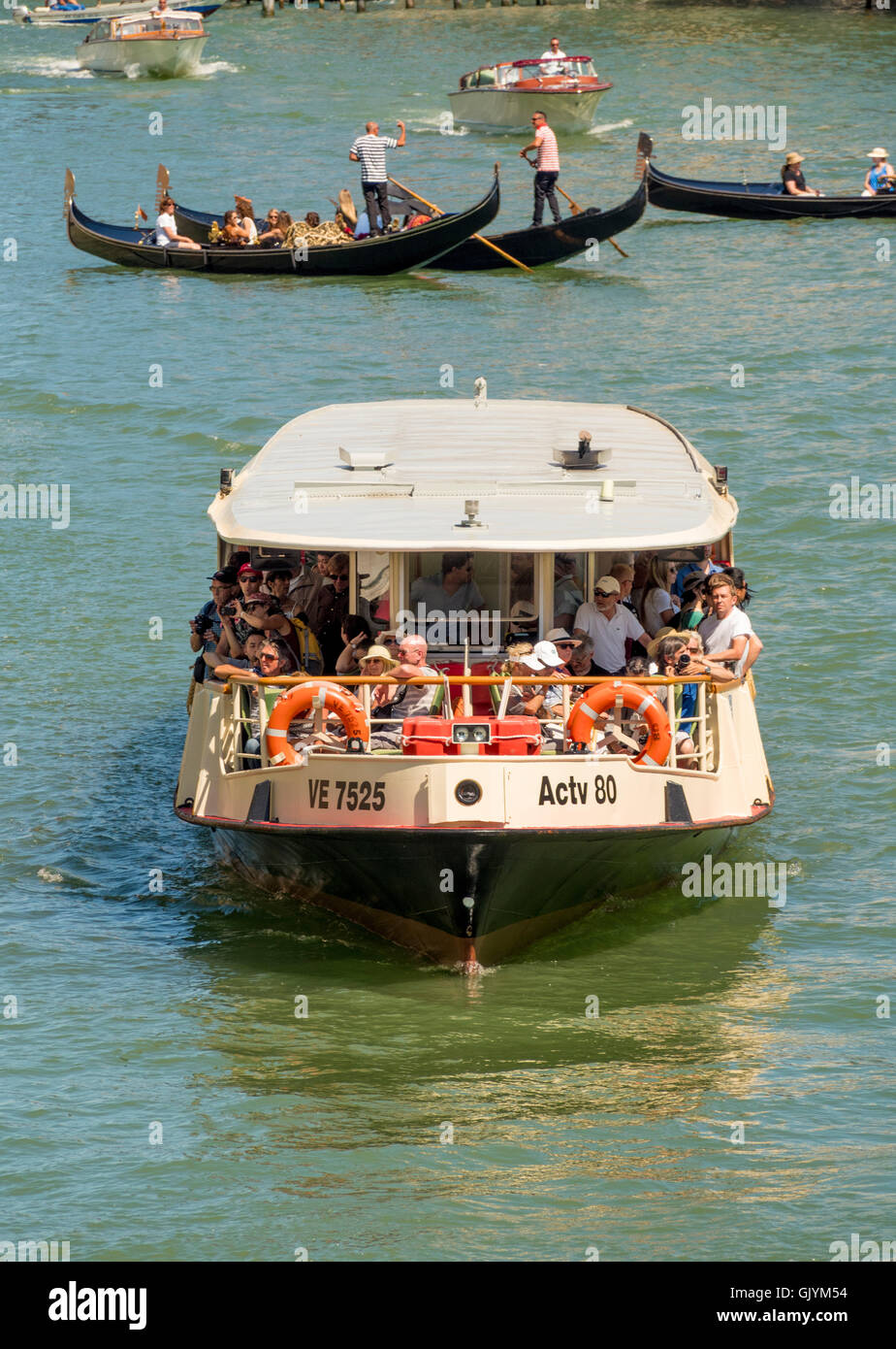 Vaporetto ou bateau-bus sur le Grand Canal avec gondoles de l'arrière-plan. Banque D'Images