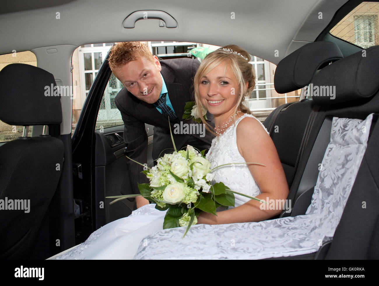 Les nouveaux mariés dans une voiture avec Strauss Banque D'Images