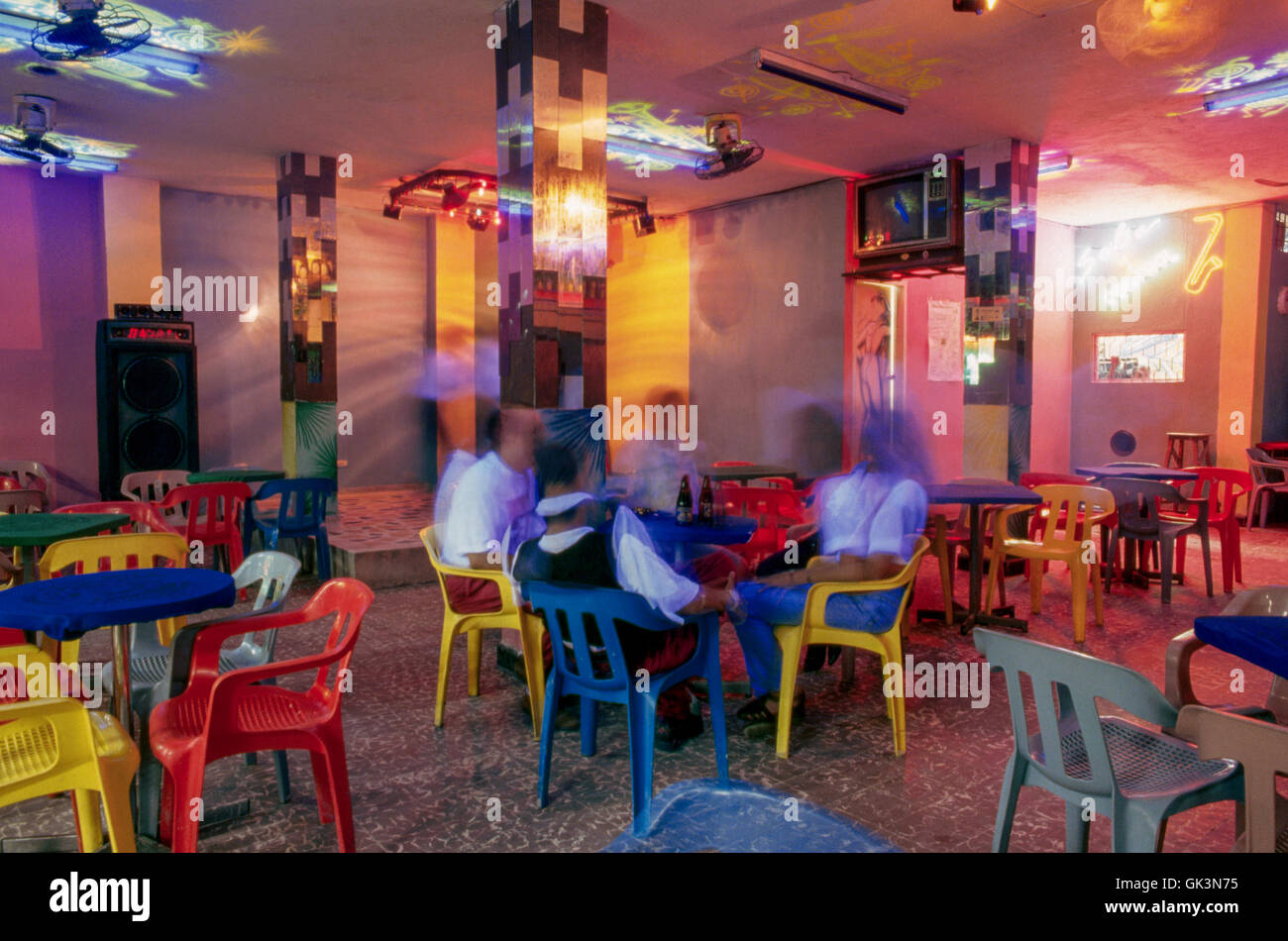 Ca. 1980-1995, Barranquilla, Colombie --- les gens boivent de la bière dans le technicolor intérieur de la discothèque Salsa, Barranquilla, Banque D'Images