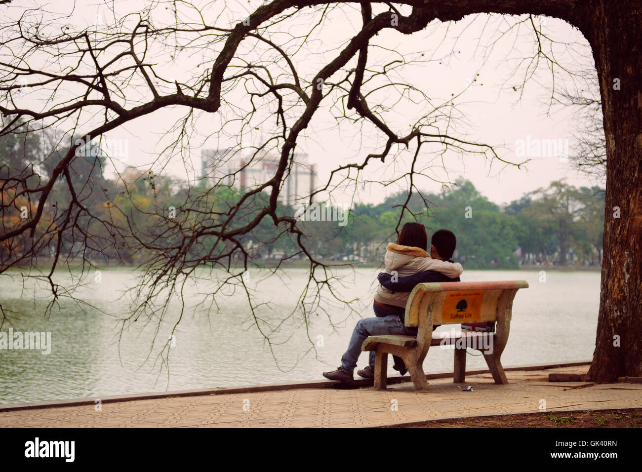 Hanoi, Vietnam - 10 mars 2012 : Le couple s'asseoir sur le banc à Hoan Kiem lake Banque D'Images