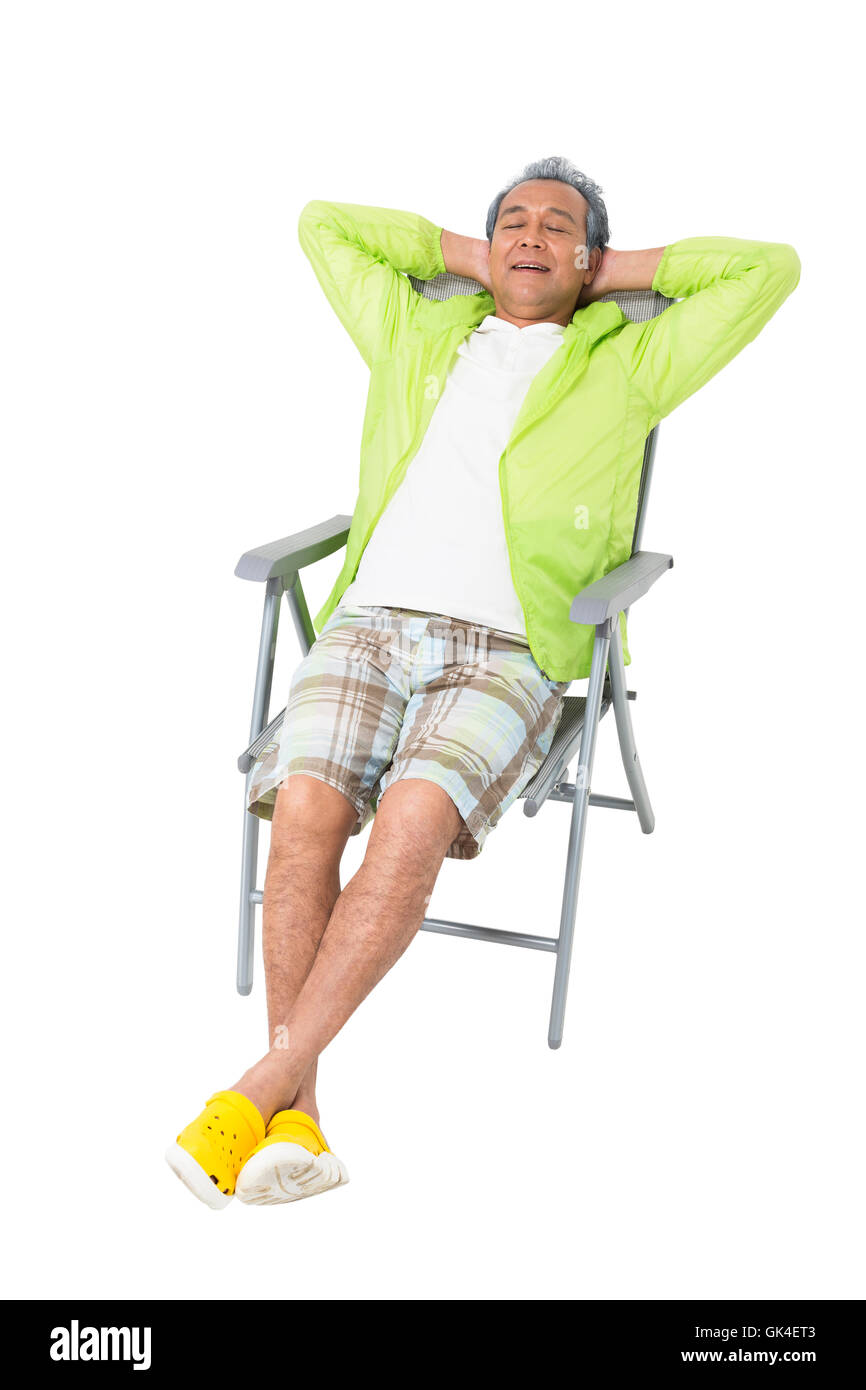 Un homme âgé assis sur une chaise de plage Banque D'Images