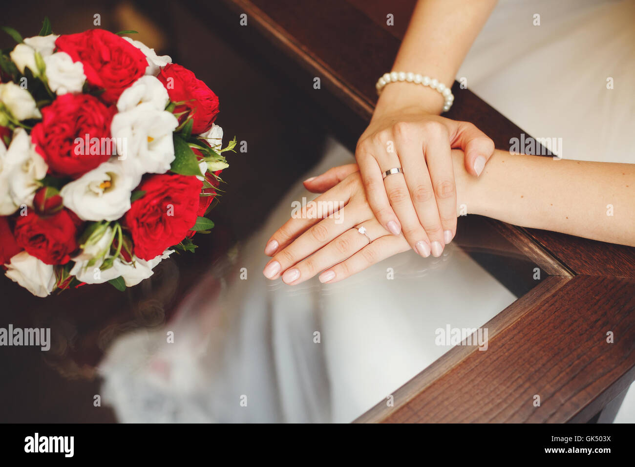 Les mains de la mariée sur une table en verre et beau mariage bouquet Banque D'Images