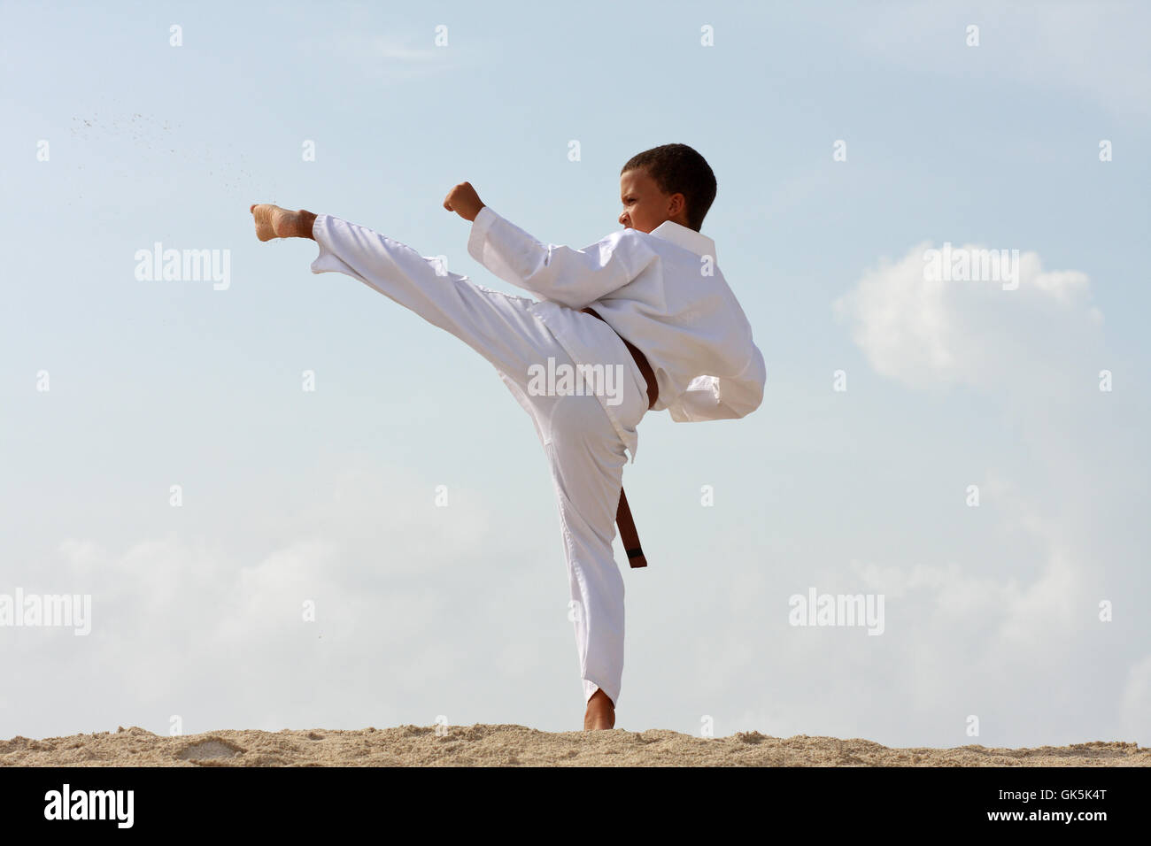 11-ans garçon faisant le Tae Kwon Do work-out sur la plage de l'île des Caraïbes. Banque D'Images