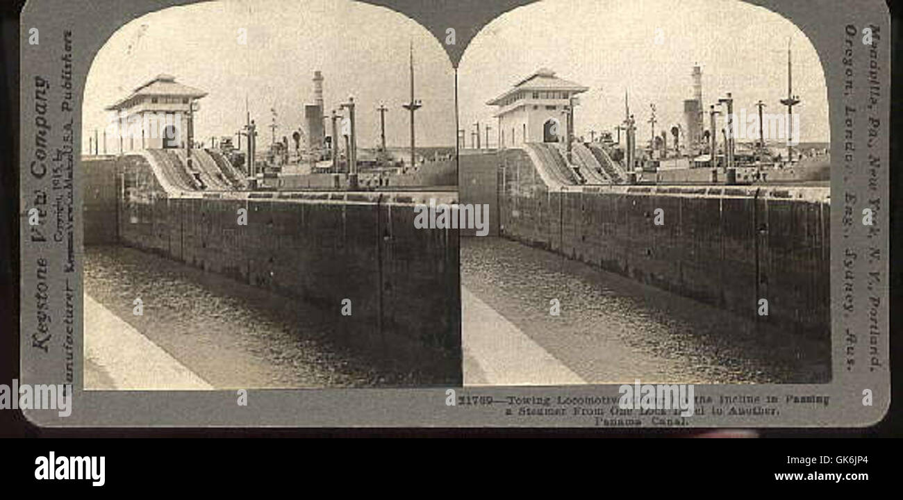 On voit une locomotive remorqueuse monter une pente en passant devant un bateau à vapeur, démontrant une manœuvre typique dans les opérations ferroviaires ou portuaires où les locomotives aident au transport de navires ou de marchandises. Banque D'Images