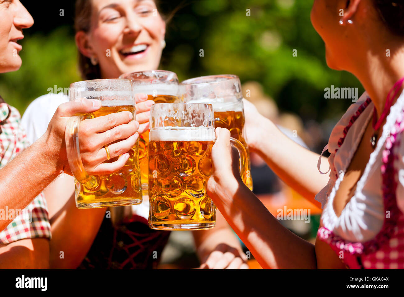 Deux couples heureux assis dans le jardin à bière Banque D'Images