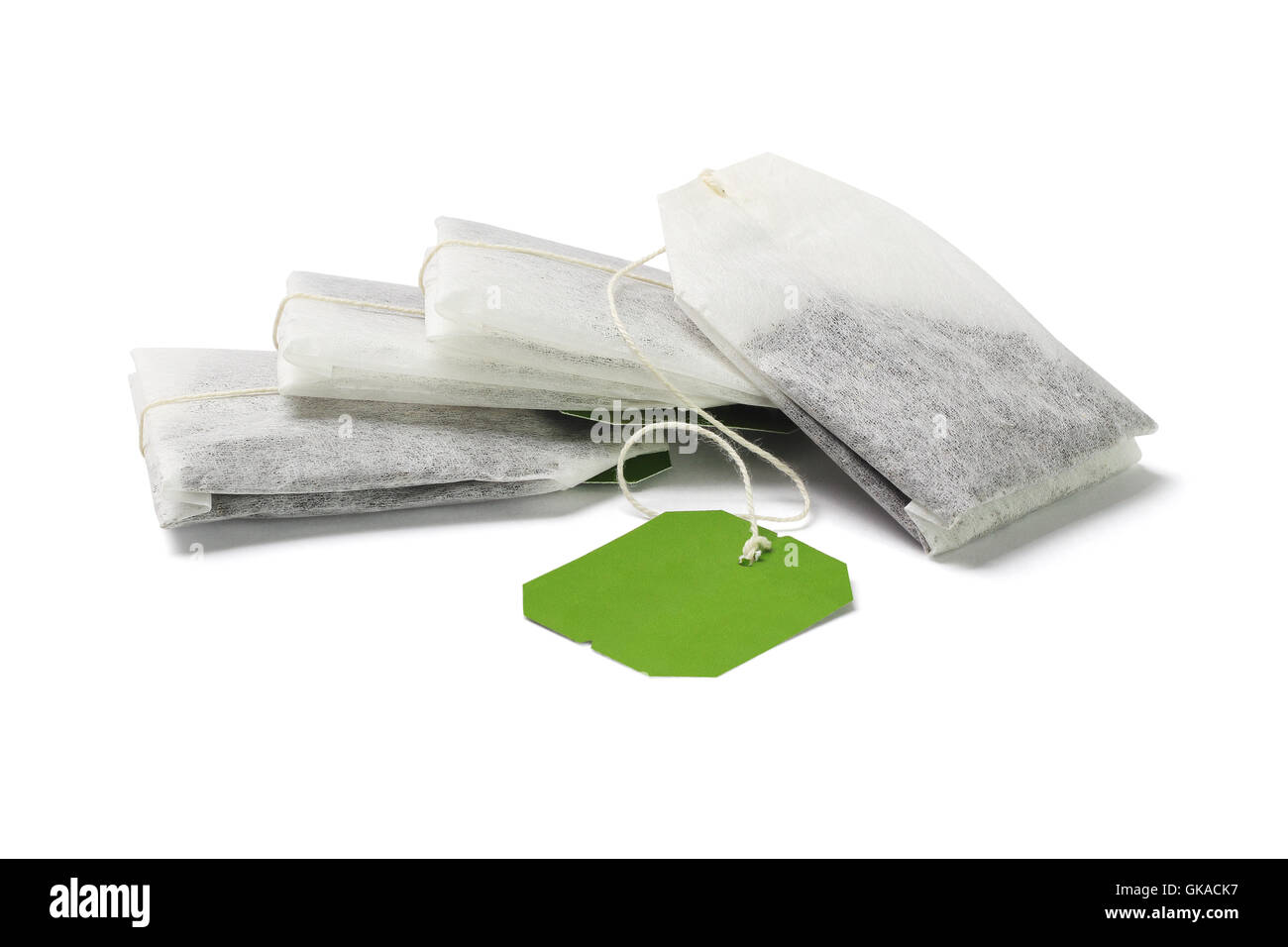 Pile de sachets de thé vert avec étiquette blanche sur fond blanc Banque D'Images