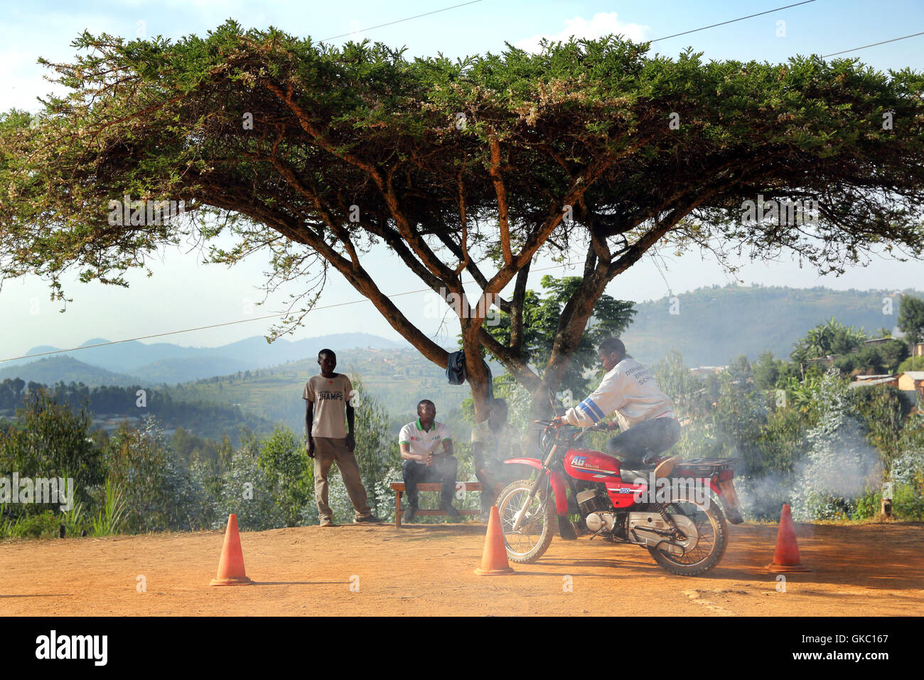 L'école de conduite pour motos sous un parapluie thorn tree à Butare, Rwanda, Afrique du Sud Banque D'Images