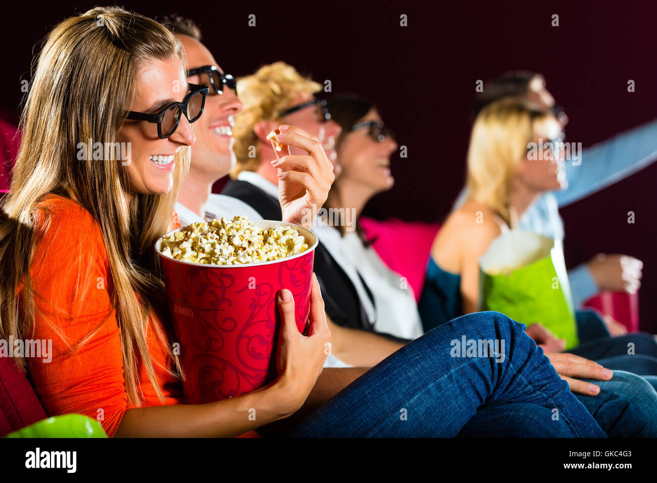 Les jeunes gens regardent un film en 3D au cinéma Banque D'Images