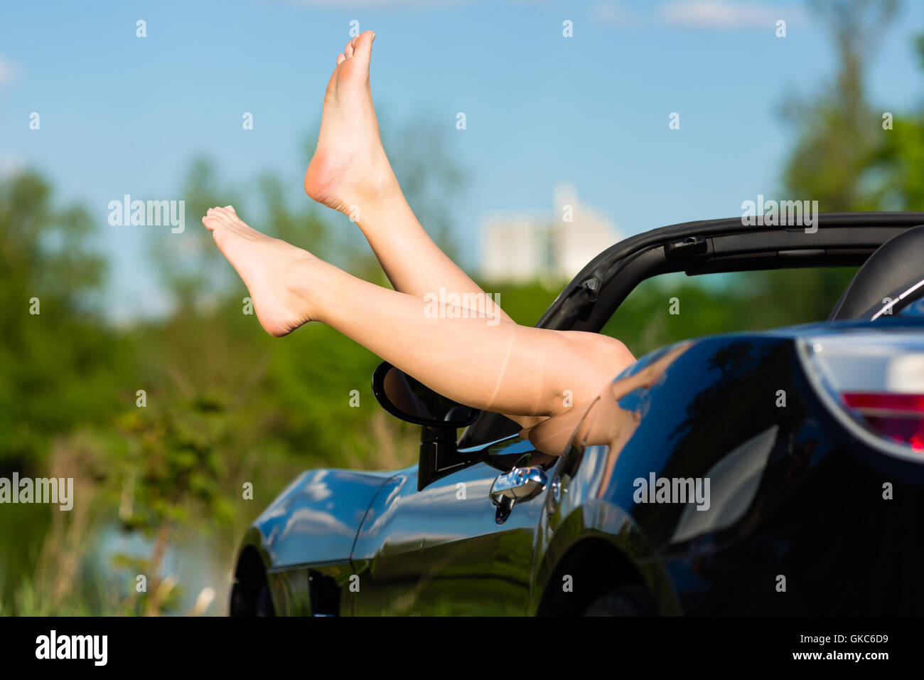 Jeune femme ou les jambes dans un cabriolet Banque D'Images