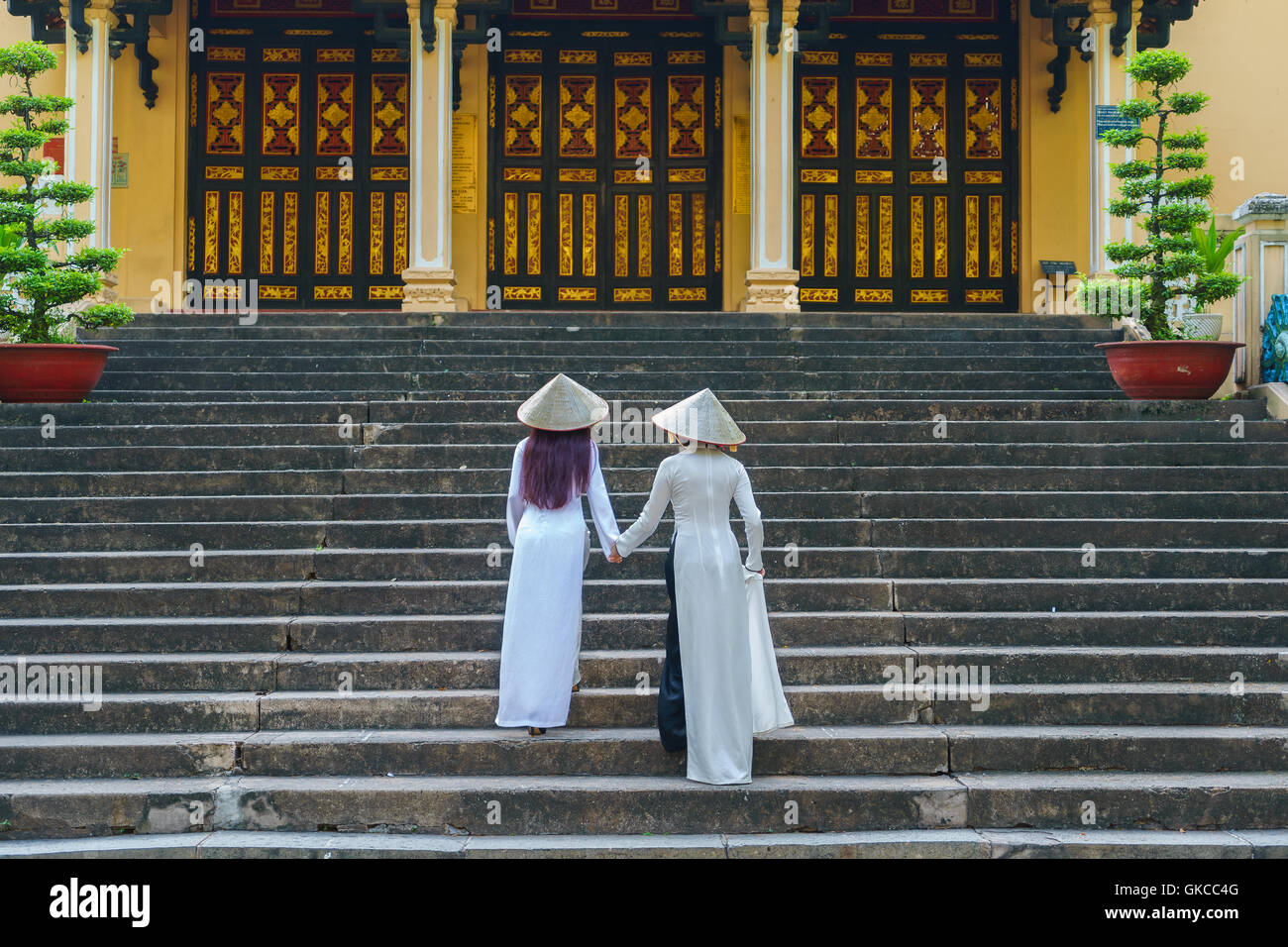 Filles vietnamiennes portant chapeau conique et ao dai (costume traditionnel vietnamien ou robe longue) au zoo de Saigon, Ho Chi Minh City, Vietnam Banque D'Images