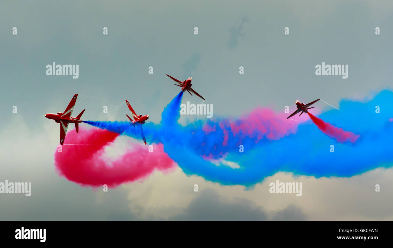 L'équipe de démonstration de la flèche rouge de la RAF 4 aéronefs entremêlés de fumée rouge et bleu Banque D'Images