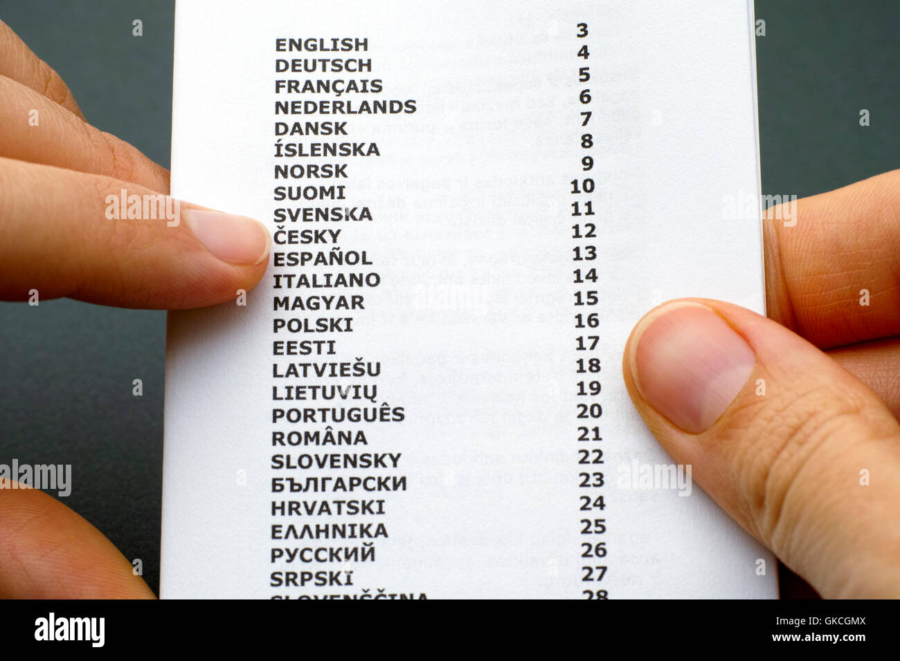 Livret avec liste des langues dans femme mains. Fond gris-vert. Banque D'Images