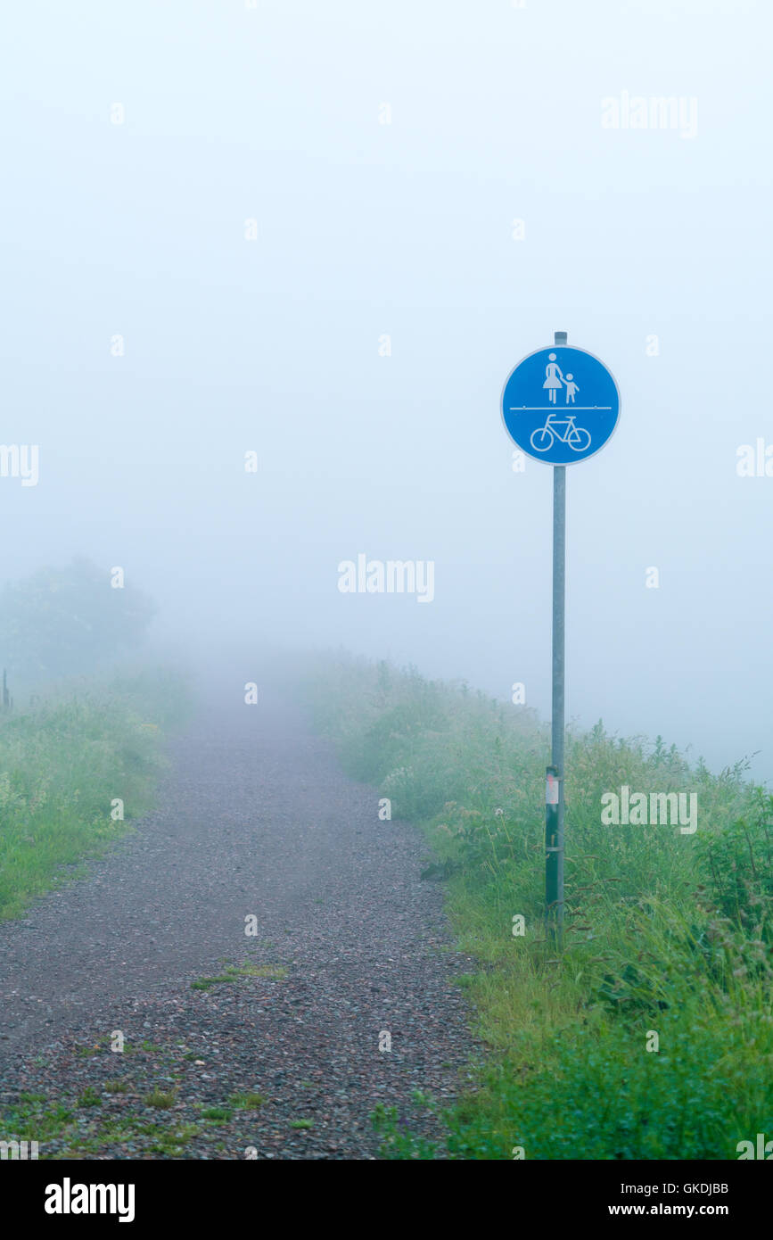 Signe de la circulation des piétons et cyclistes dans le brouillard Banque D'Images