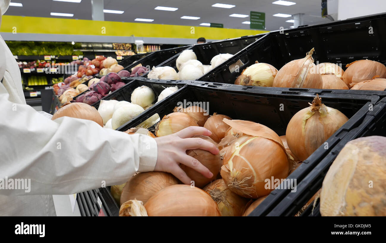 Woman picking oignon frais à l'intérieur magasin Walmart Banque D'Images