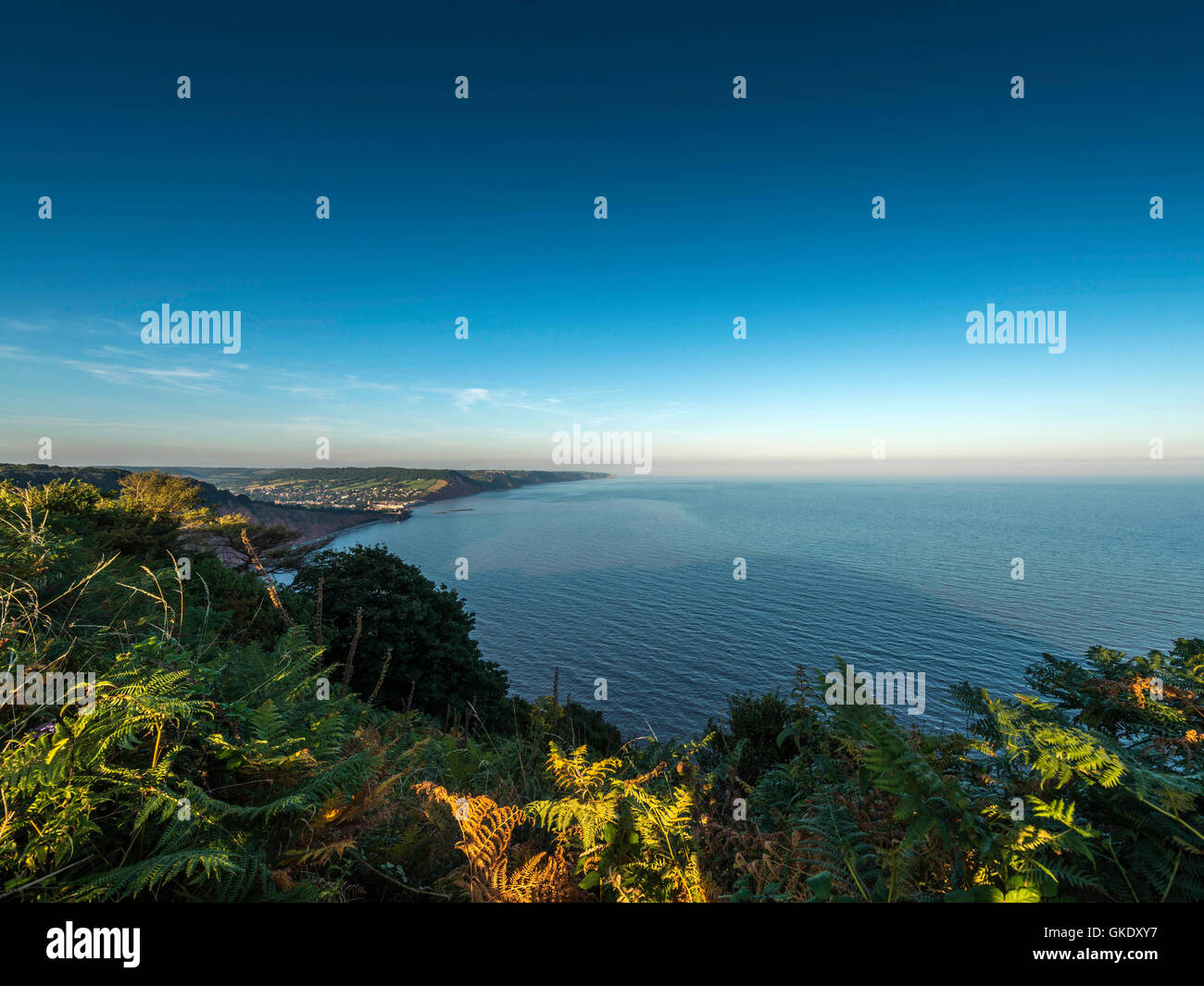 Représentant le paysage coucher du soleil et de la lune montée le long de la côte jurassique près de jolie ville balnéaire côtière de Sidmouth. Banque D'Images