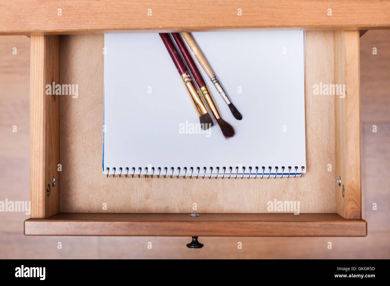 Voir ci-dessus de pinceaux sur le dessin album dans tiroir de table de nuit Banque D'Images