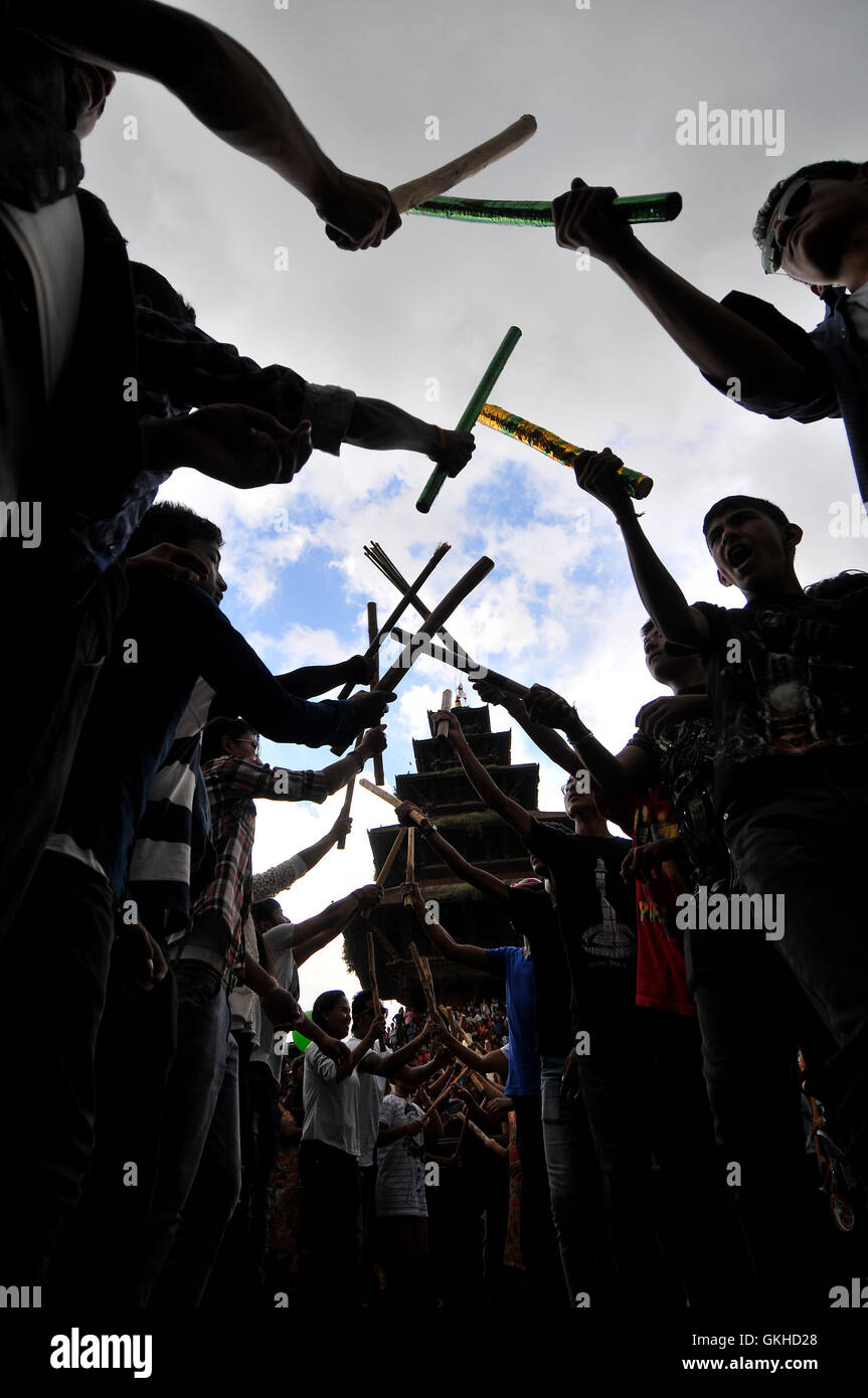 Katmandou, Népal. Août 19, 2016. Les jeunes Népalais dance avec des bâtons qu'ils prennent part à une procession au cours de Gai Jatra ou vache festival célébré dans Bhaktapur, Népal le 19 août 2016. À l'occasion de Gai Jatra ou vache Festival, peuple népalais célèbre par le souvenir a diminué, et rendre hommage à l'appareille d'âmes. Une vache est considéré comme saint par les Hindous, qui pense qu'il aidera le parent décédé, votre voyage au ciel. © Narayan Maharjan/Pacific Press/Alamy Live News Banque D'Images