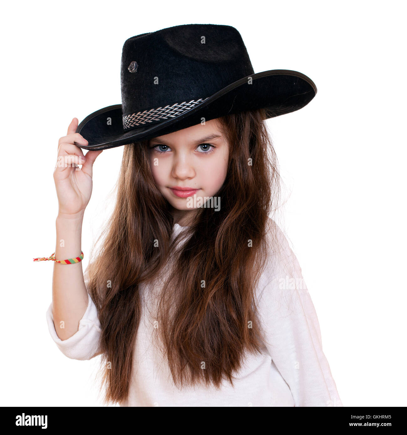 Portrait d'une belle petite fille dans un chapeau de cow-boy noir, blanc fond isolé sur studio Banque D'Images