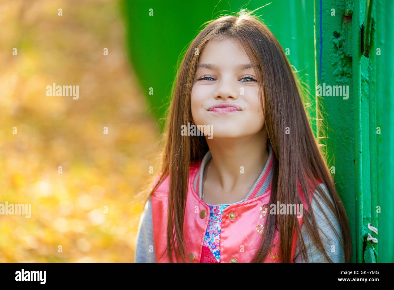 Cose, belle petite fille sur fond vert de summer city park Banque D'Images