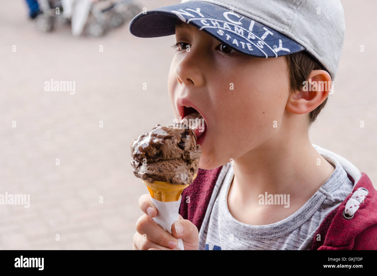 Un jeune garçon jouit d'une glace au chocolat. Banque D'Images