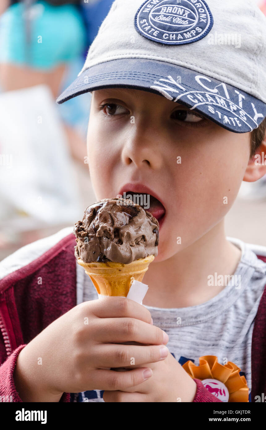 Un jeune garçon jouit d'une glace au chocolat. Banque D'Images