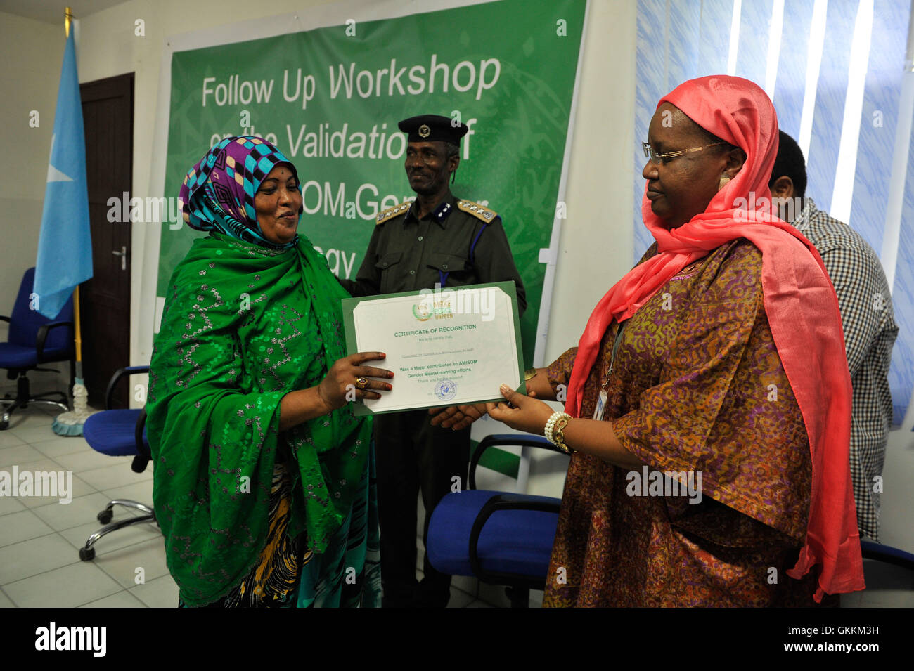 Le Représentant spécial adjoint du président de la Commission de l'Union africaine (DSRCC) pour la Somalie, Lydia Wanyoto, mains un certificat de reconnaissance pour le peuple somalien, membre du Parlement Mariam Moalim, au cours de l'atelier de suivi sur la validation de la stratégie de l'AMISOM a tenu à Mogadiscio, en Somalie, le 7 août 2015. L'atelier a été organisé et appuyé par l'AMISOM en matière d'unité. L'AMISOM Photo/Omar Abdisalan Banque D'Images