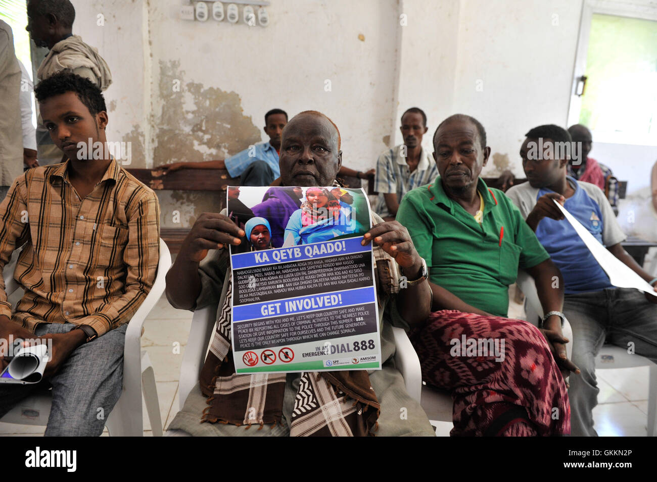 Un somalien tient une affiche de la police communautaire lors d'une Assemblée publique dans le district de Karan, à Mogadiscio, le 10 septembre 2015. L'événement visait à renforcer la coopération entre les autorités locales, la police de l'AMISOM et les résidents. Banque D'Images