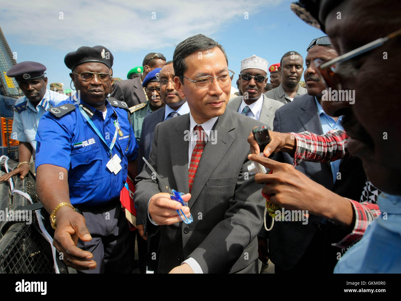 Toshihisa Takata, ambassadeur du Japon au Kenya, se prépare à couper le ruban lors d'une cérémonie de remise à Mogadiscio le 7 mai. L'événement a marqué le don de matériel, dont 15 camionnettes, deux ambulances, des casques balistiques et des radios VHF, pour aider à la reconstruction de la Force de police somalienne (SPF). AMISOM photo. Banque D'Images
