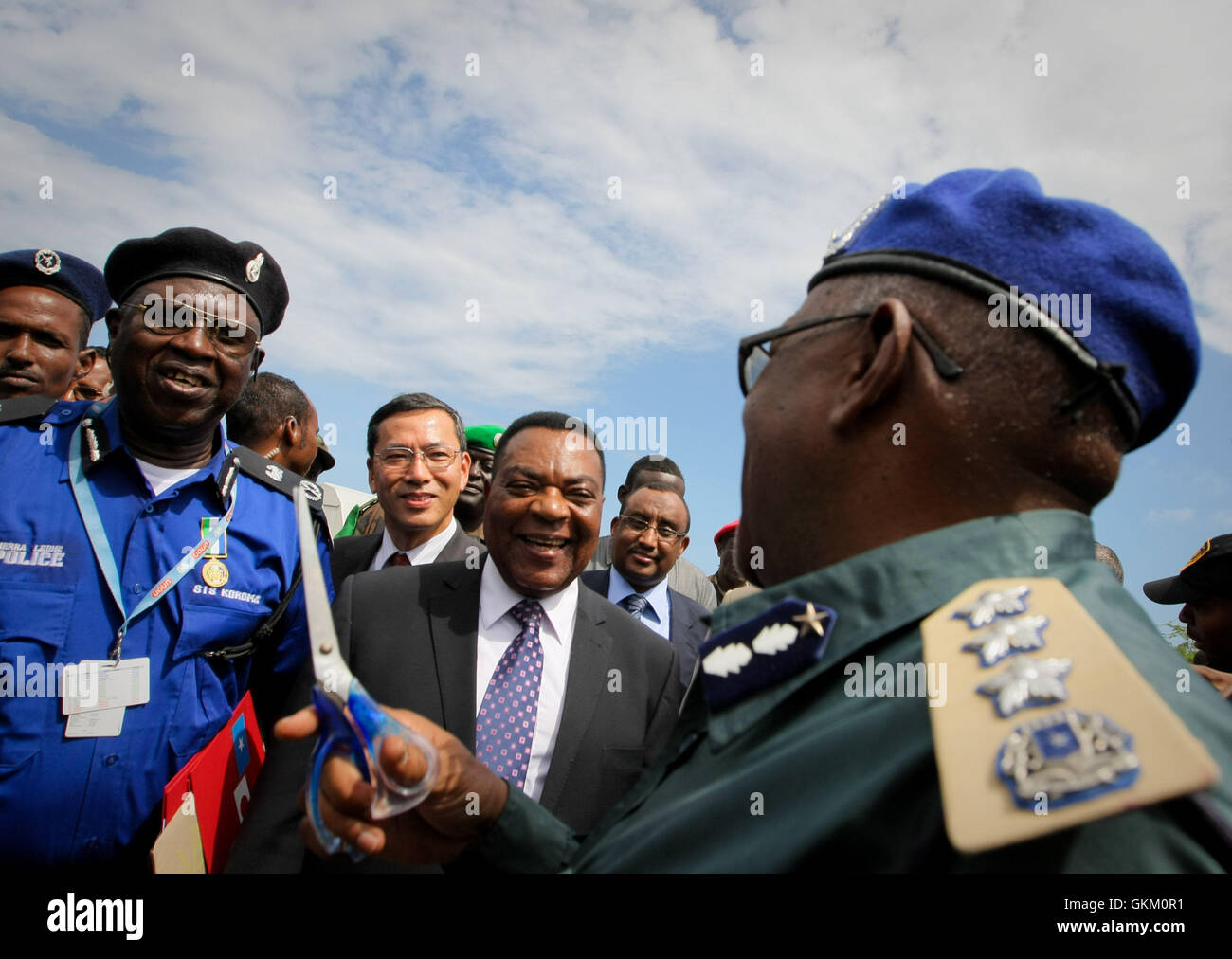 La Somalie, Mogadiscio : Dans une photographie mis à disposition par l'Union africaine et l'équipe de support d'information des Nations Unies 7 mai, Représentant spécial du Secrétaire général des Nations Unies, Augustine Mahiga (centre) s'entretient avec le commissaire de police somalie Sharif Sekhuna Mayi (à droite) avant de couper le ruban lors d'une cérémonie de transfert de matériel donné par le Gouvernement du Japon à travers le Bureau politique des Nations Unies pour la Somalie (UNPOS) Fonds en fiducie pour soutenir la reconstruction de la SPF dans la capitale Mogadishu. L'équipement inclus un transport flotte de 15 camionnettes, deux membres du personnel de troupes carr Banque D'Images