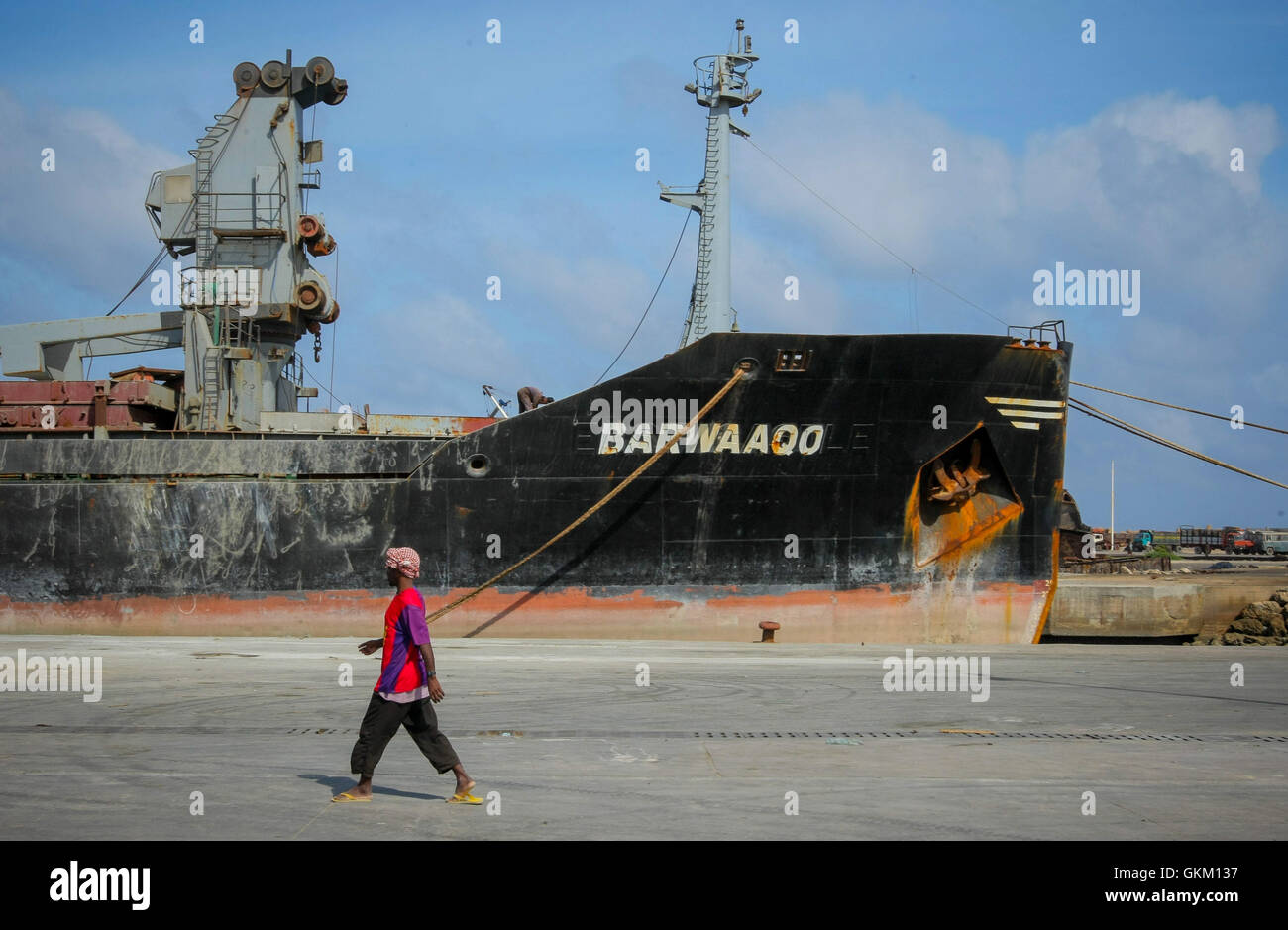 Le 6 août 2012, un docker passe devant un navire au port de Mogadiscio, marquant un an depuis qu’Al Shabaab s’est retiré de positions fixes dans la ville, mettant fin à leur contrôle de la zone portuaire de la capitale. Banque D'Images
