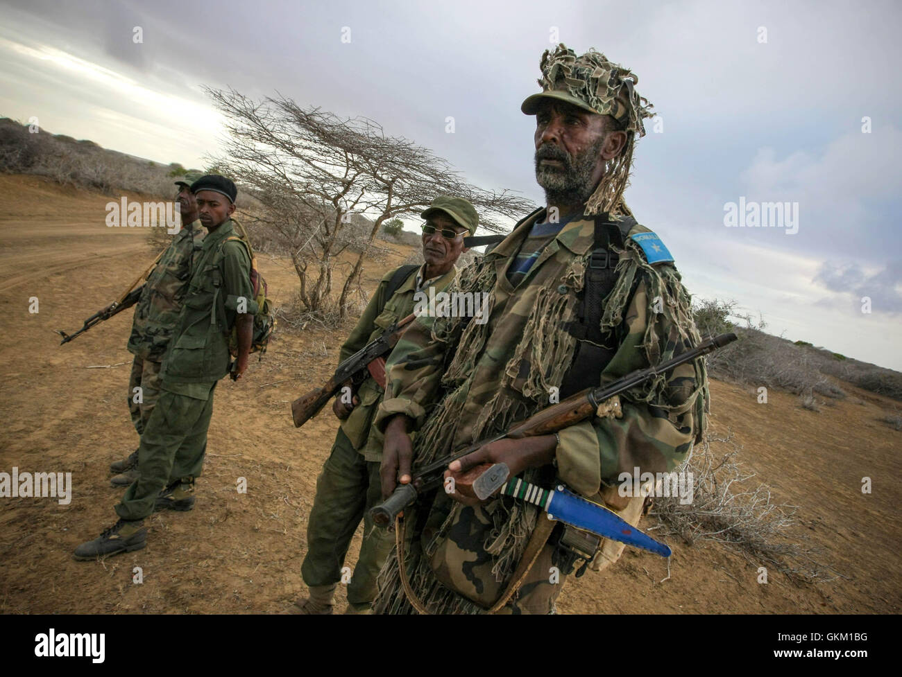 Les soldats de la SNA observent alors que les troupes kenyanes de l'AMISOM avancent dans Kismayo, la ville portuaire stratégique de Somalie, le 2 octobre 2012. L'opération faisait partie des efforts en cours pour démanteler le contrôle d'Al-Shabaab dans le sud de la Somalie, culminant avec la capture pacifique de la ville. Banque D'Images